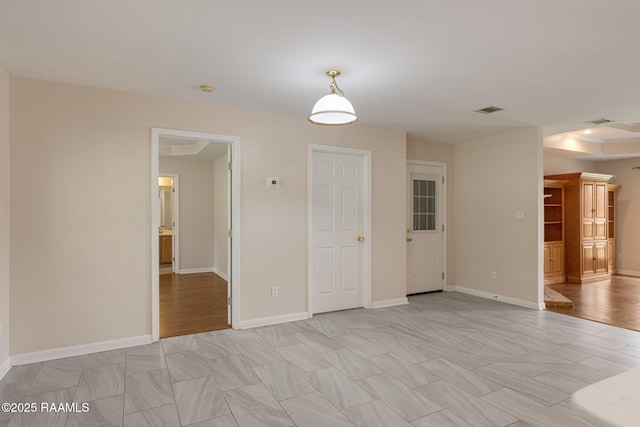 unfurnished room featuring visible vents and baseboards