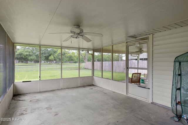 unfurnished sunroom featuring ceiling fan and plenty of natural light