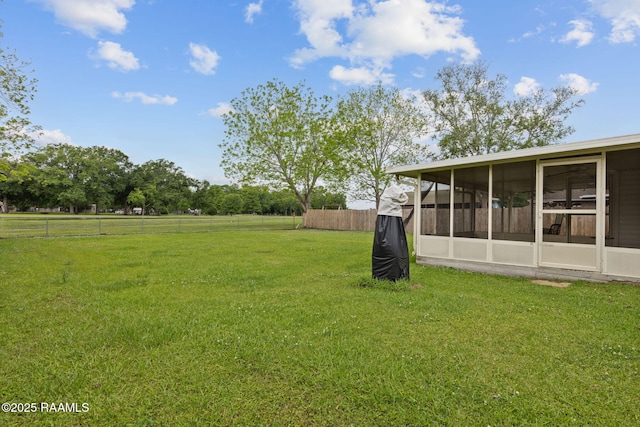 view of yard featuring fence and a sunroom