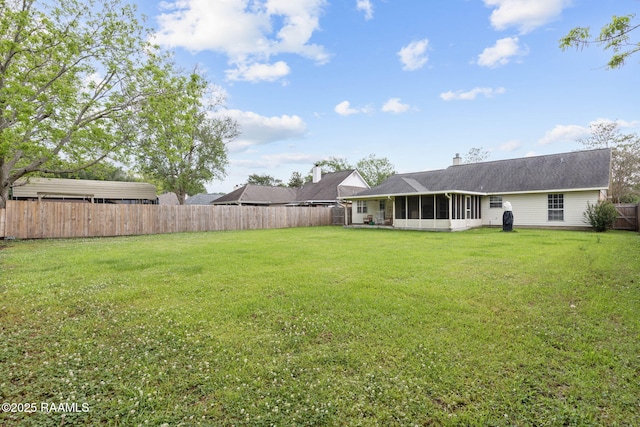 view of yard featuring a sunroom and a fenced backyard