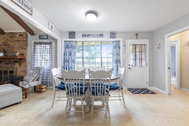 103 Failla Rd, Lafayette, LA 70508 - dining area featuring baseboards, a brick fireplace, and a textured ceiling