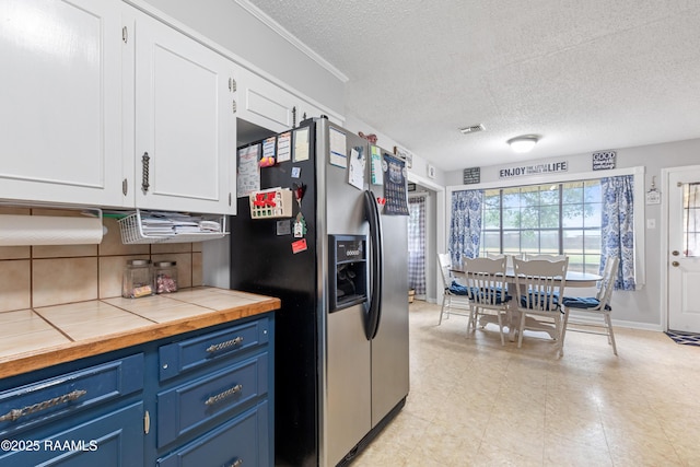 103 Failla Rd, Lafayette, LA 70508 - kitchen featuring tile counters, blue cabinets, stainless steel fridge with ice dispenser, white cabinetry, and visible vents