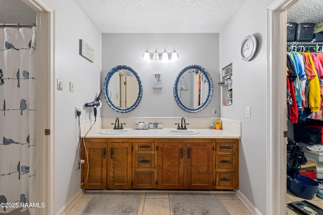 103 Failla Rd, Lafayette, LA 70508 - bathroom with double vanity, a textured ceiling, tile patterned flooring, and a sink