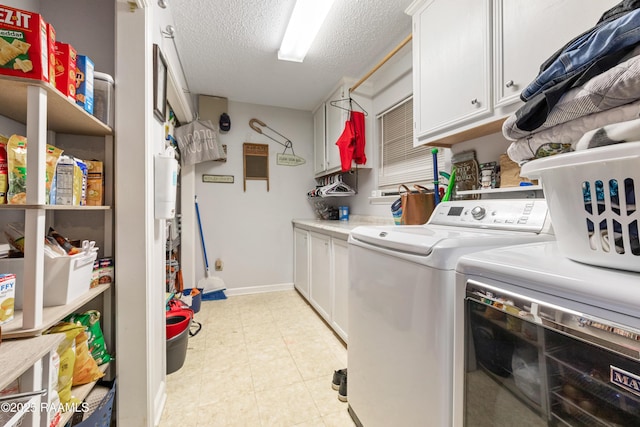 103 Failla Rd, Lafayette, LA 70508 - laundry room with washing machine and dryer, a textured ceiling, and cabinet space