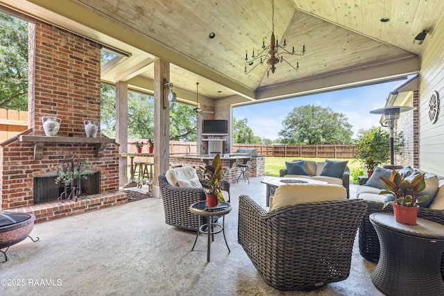view of patio with a fenced backyard, an outdoor living space with a fireplace, and outdoor dry bar