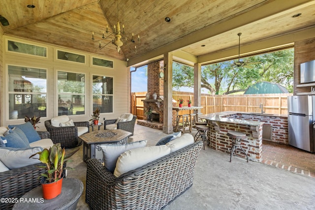 exterior space featuring an outdoor living space with a fire pit, a sink, a wealth of natural light, and outdoor dry bar