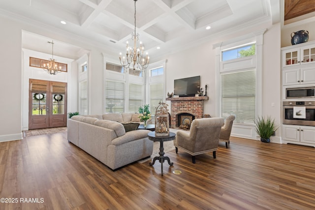 living room featuring an inviting chandelier, plenty of natural light, dark wood finished floors, and a towering ceiling