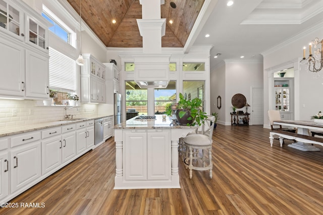 kitchen featuring white cabinets, stainless steel appliances, wood finished floors, and a center island