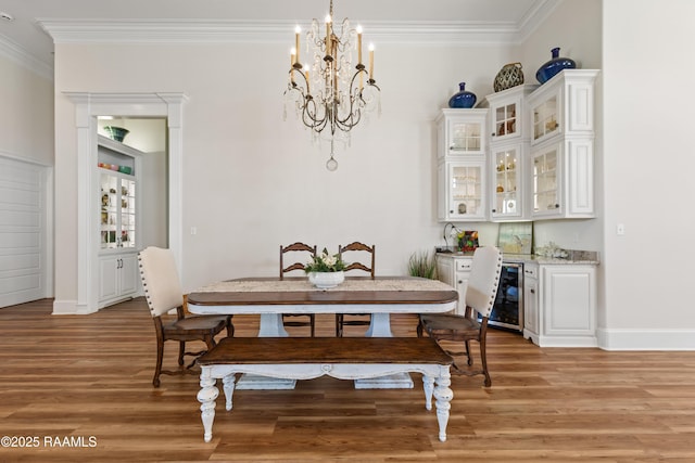 dining room with crown molding, a bar, light wood finished floors, a notable chandelier, and wine cooler