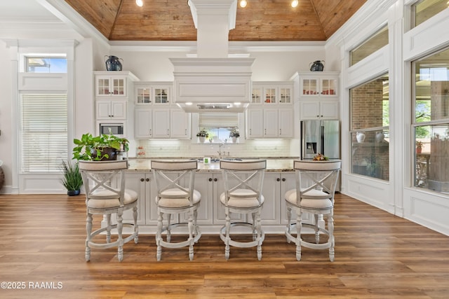 kitchen featuring white cabinetry, tasteful backsplash, a kitchen island, ornamental molding, and wood ceiling