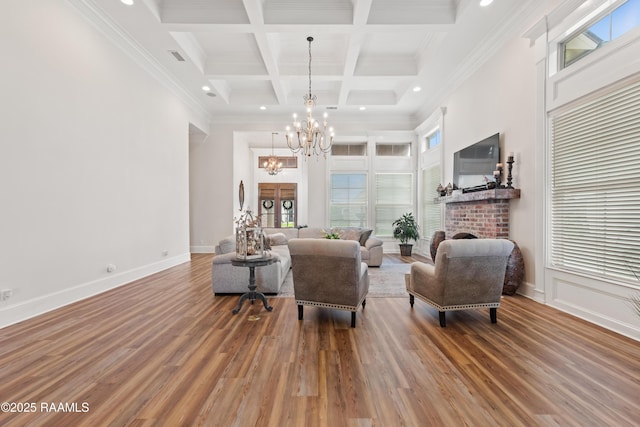 living area featuring an inviting chandelier, wood finished floors, a wealth of natural light, and beamed ceiling