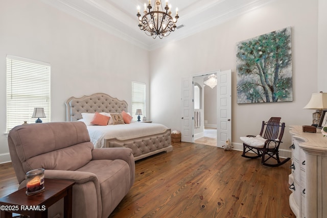 bedroom featuring crown molding, baseboards, dark wood-style floors, a notable chandelier, and a high ceiling