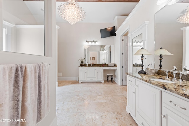bathroom with an inviting chandelier, a sink, and two vanities
