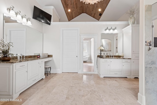 full bathroom with visible vents, a freestanding tub, vaulted ceiling, two vanities, and a sink