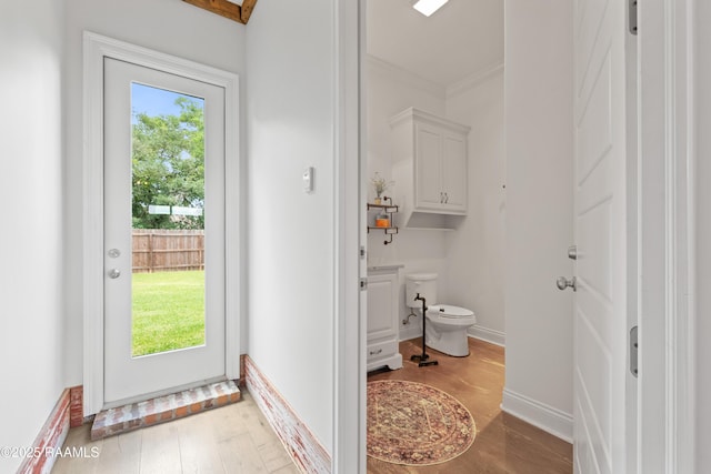 bathroom with wood finished floors, a wealth of natural light, and toilet