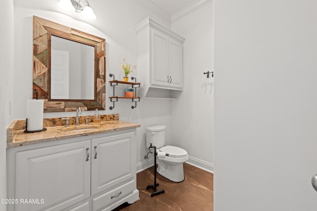 bathroom with crown molding, concrete flooring, vanity, toilet, and baseboards