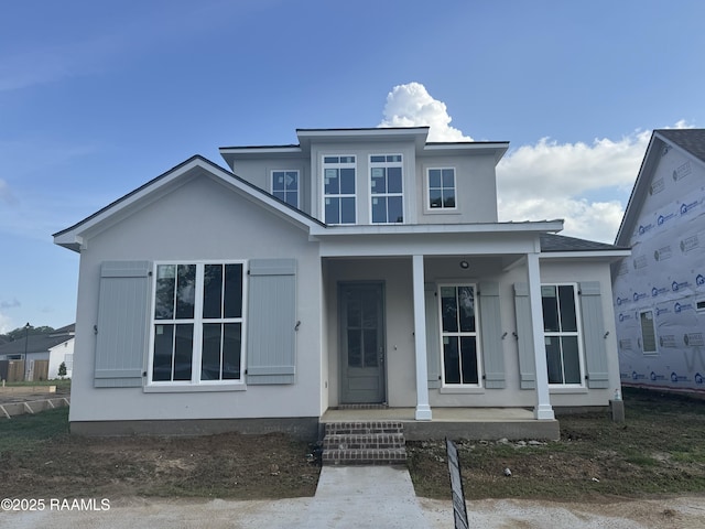 view of front of house featuring covered porch and stucco siding