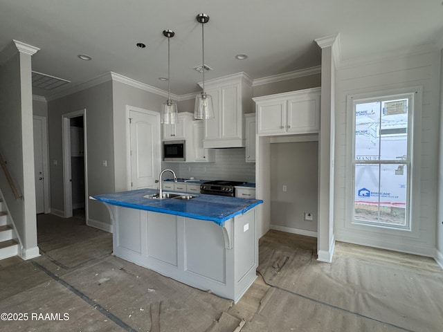 kitchen with tasteful backsplash, appliances with stainless steel finishes, dark countertops, a sink, and white cabinetry