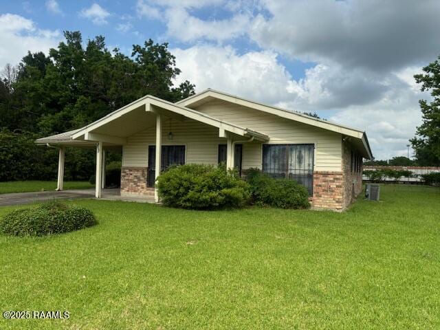 1614 Norway St, Opelousas, LA 70570 - view of front of home with brick siding, a front yard, a carport, and concrete driveway