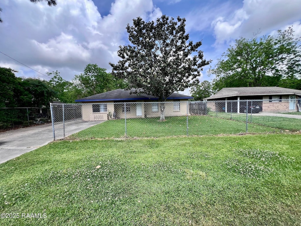 view of front of house featuring a front lawn, concrete driveway, and fence