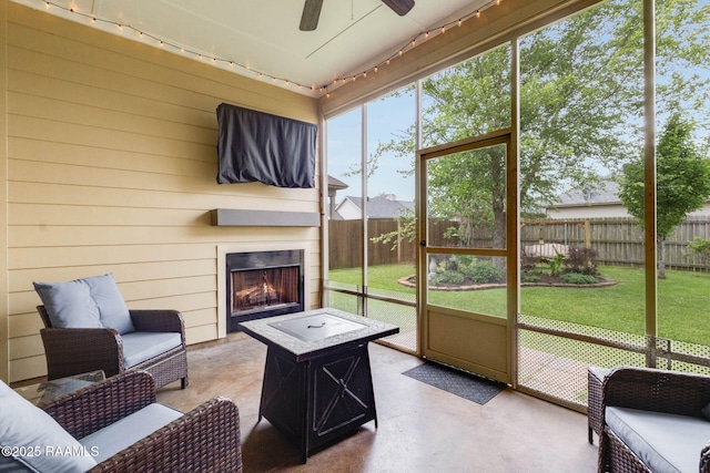 sunroom / solarium featuring an outdoor living space with a fireplace and ceiling fan