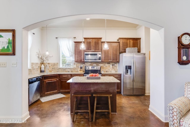 kitchen with decorative backsplash, a sink, stainless steel appliances, and finished concrete floors