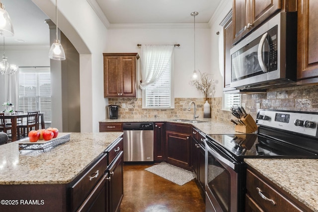 kitchen featuring a sink, light stone countertops, crown molding, tasteful backsplash, and appliances with stainless steel finishes