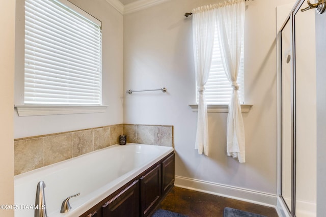 bathroom featuring a shower stall, a garden tub, baseboards, and ornamental molding