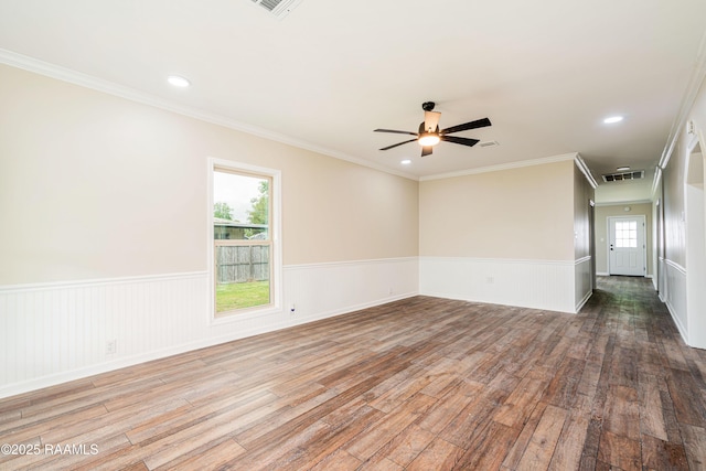813 S Arenas St, Rayne, LA 70578 - empty room featuring crown molding, wood finished floors, wainscoting, ceiling fan, and visible vents