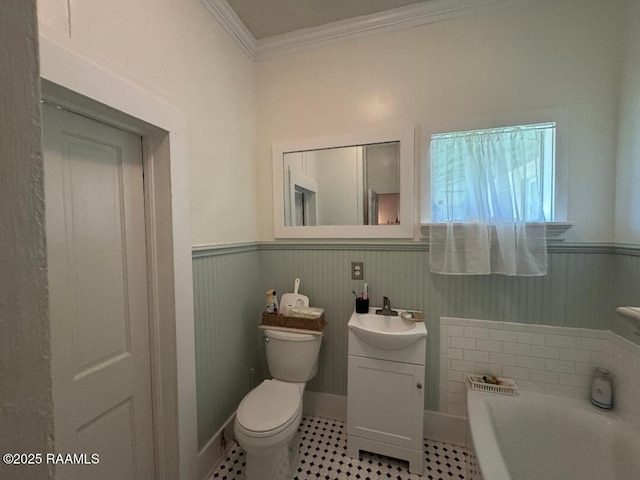 full bathroom featuring crown molding, a wainscoted wall, a garden tub, and toilet