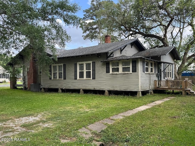 back of house with a lawn, central AC unit, a chimney, and a wooden deck