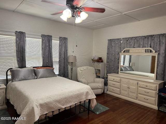 bedroom featuring ceiling fan, multiple windows, and hardwood / wood-style flooring
