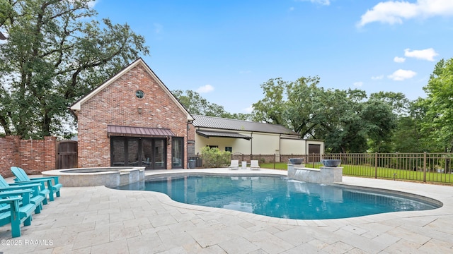 view of swimming pool featuring a patio, fence, and a pool with connected hot tub