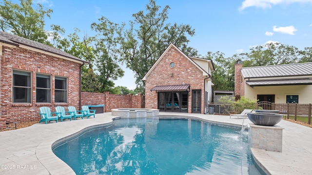 view of pool featuring a patio, a fenced backyard, and a pool with connected hot tub