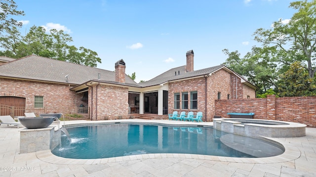 view of pool featuring a patio area, a pool with connected hot tub, and fence