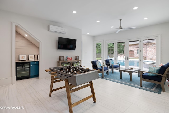rec room with a wall mounted air conditioner, ceiling fan, recessed lighting, beverage cooler, and french doors