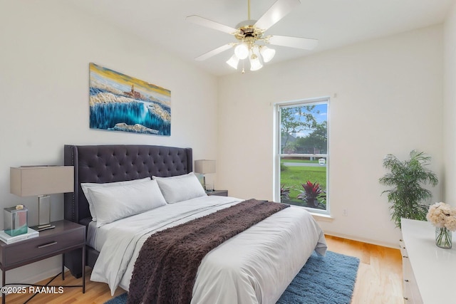 bedroom with a ceiling fan and light wood-type flooring