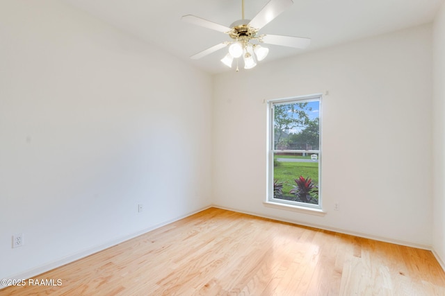 unfurnished room featuring ceiling fan, light wood-style flooring, and baseboards