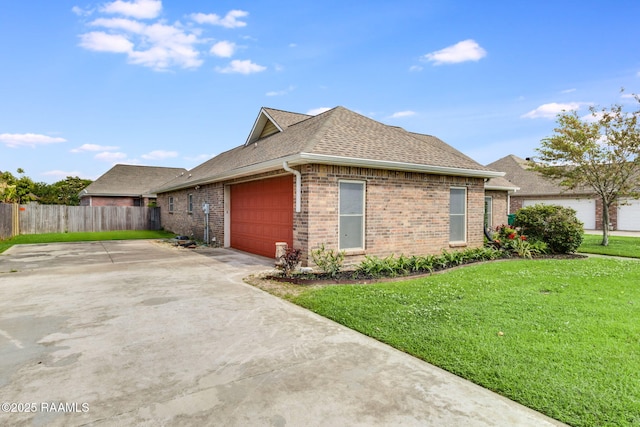 view of home's exterior featuring brick siding, fence, a shingled roof, and a yard