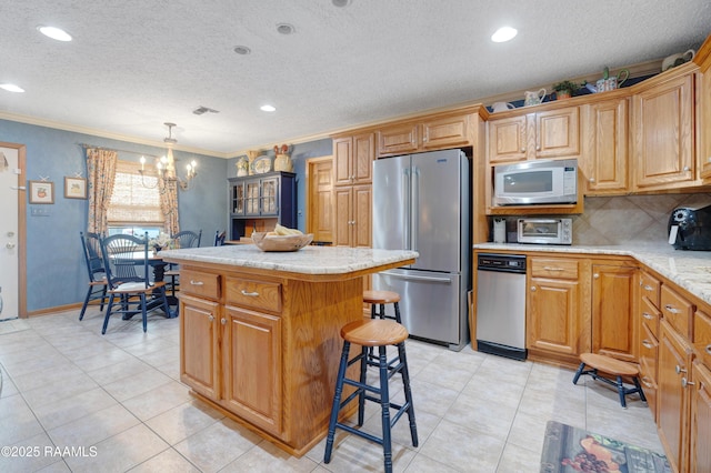 kitchen with light countertops, a textured ceiling, a center island, freestanding refrigerator, and white microwave