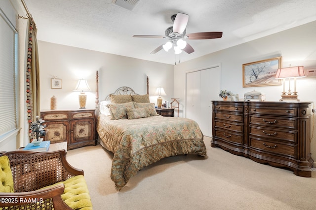 carpeted bedroom with visible vents, ceiling fan, and a closet