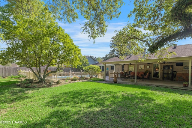 view of yard with a ceiling fan, a fenced backyard, and a patio area
