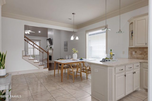 313 Summerland Key Ln, Lafayette, LA 70508 - kitchen with decorative backsplash, pendant lighting, a peninsula, and ornamental molding