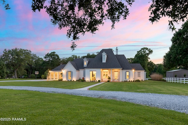 view of front facade featuring a lawn and a chimney