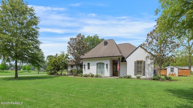 french provincial home with a front yard and roof with shingles