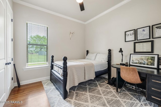 bedroom with baseboards, a ceiling fan, wood finished floors, and ornamental molding