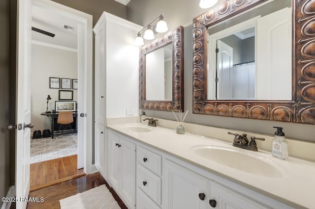 bathroom featuring ornamental molding, double vanity, a sink, and visible vents