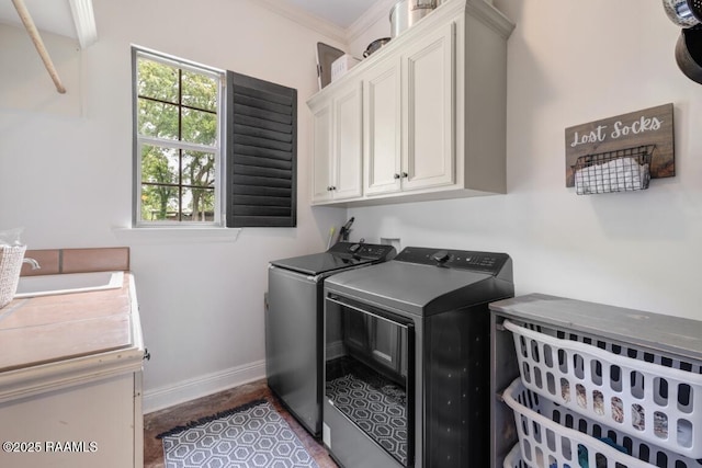 laundry area featuring a sink, washing machine and dryer, baseboards, ornamental molding, and cabinet space