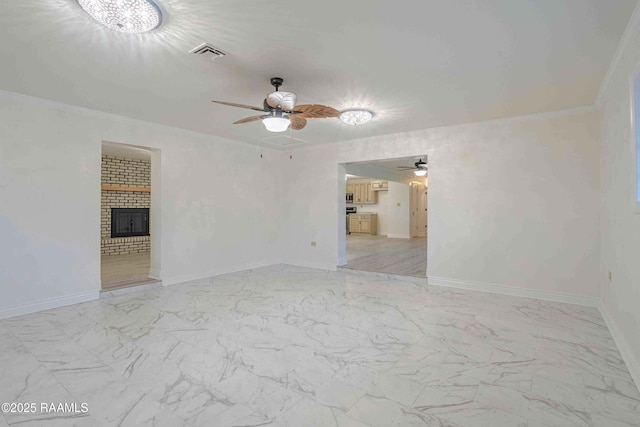 1706 Fuselier Rd, Arnaudville, LA 70512 - spare room featuring ceiling fan, light marble finish floors, baseboards, a fireplace, and crown molding