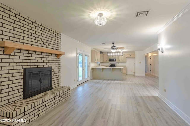 1706 Fuselier Rd, Arnaudville, LA 70512 - unfurnished living room featuring crown molding, baseboards, light wood-type flooring, a fireplace, and ceiling fan